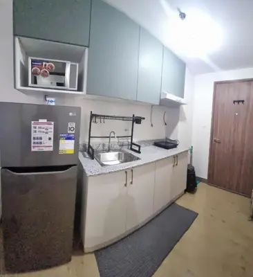 a small kitchen with a sink and a refrigerator at Bicutan Urban Haven in Manila
