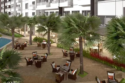 a rendering of a courtyard with chairs and palm trees at Bicutan Urban Haven in Manila
