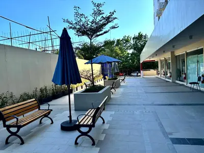 a patio with benches and an umbrella next to a building at Casa Del Hasmin in Puting Kahoy