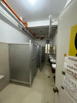 a bathroom with a row of sinks and toilets at St John's Pearl Transient House in Manila