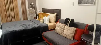 a bedroom with a bed and a couch and a chair at Luxury Resort Condo in Pasig FastWifiPoolSmartLock in Manila