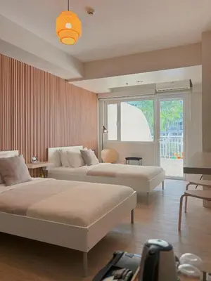 a large room with two beds and a window at Manila Staycation Rental in Manila