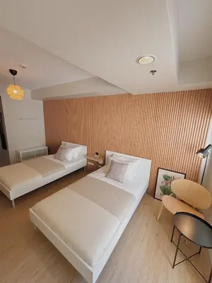a hotel room with two beds and a chair at Manila Staycation Rental in Manila