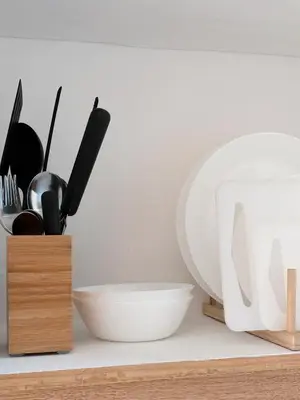 a shelf with utensils and a bowl and a plate at Manila Staycation Rental in Manila