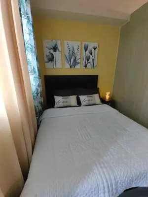 a bed in a bedroom with paintings on the wall at Condo Near MOA, NAIA, PICC, & CCP that is comfy with a view! in Manila