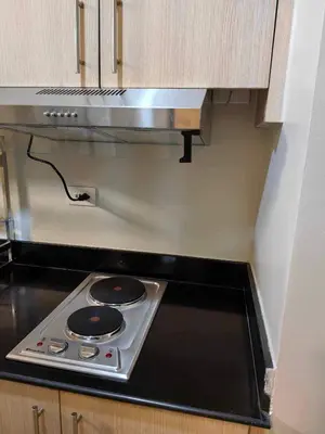 a kitchen with a stove top oven in a kitchen at Condo Near MOA, NAIA, PICC, & CCP that is comfy with a view! in Manila