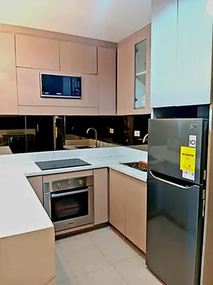 a kitchen with a stainless steel refrigerator and cabinets at California Suite - by GUEST RESERVATION'S MANILA in Manila