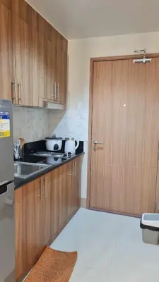a kitchen with wooden cabinets and a sink and a door at One bedroom with Balcony-M&M City Comfort in Manila