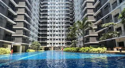 a large apartment building with a large swimming pool at One bedroom with Balcony-M&M City Comfort in Manila