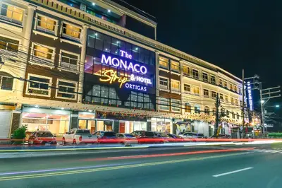 a large building with cars parked in front of it at Monaco Hotel in Taytay