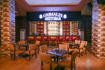 a restaurant with tables and chairs and a bar at Monaco Hotel in Taytay
