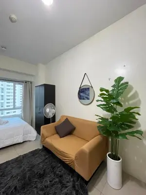 a living room with a couch and a potted plant at Mountain View at Beacon Tower in Manila