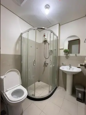 a bathroom with a shower and a toilet and a sink at Mountain View at Beacon Tower in Manila