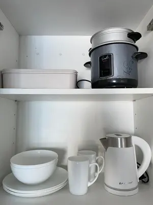 a kitchen shelf with dishes and a pot and cups at Mountain View at Beacon Tower in Manila