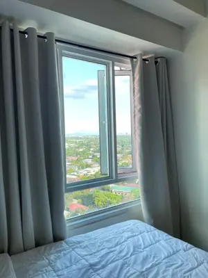 a bedroom with a bed and a large window at Mountain View at Beacon Tower in Manila