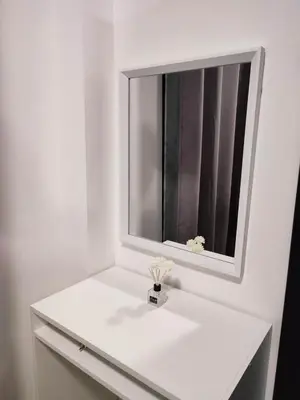 a white bathroom with a mirror and a white sink at Shatze's Place-One Bedroom Pool view near MOA and Airport in Manila