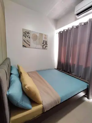 a bed sitting in a room with curtains at Shatze's Place-One Bedroom Pool view near MOA and Airport in Manila