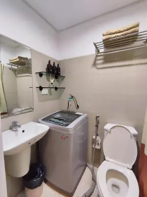 a bathroom with a toilet and a sink at Shatze's Place-One Bedroom Pool view near MOA and Airport in Manila