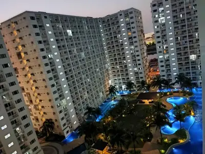 a view of two tall buildings at night at Shatze's Place-One Bedroom Pool view near MOA and Airport in Manila
