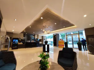 a lobby with chairs and a table in a building at Shatze's Place-One Bedroom Pool view near MOA and Airport in Manila