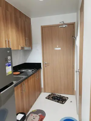 a kitchen with a wooden door and a counter top at MOA Shore 3 tower 2 in Manila