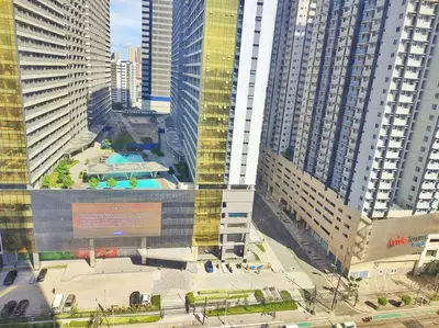 a building with a pool in a city with tall buildings at Urban Deca EDSA Budget Place w/ Unli Wi-Fi Netflix in Manila