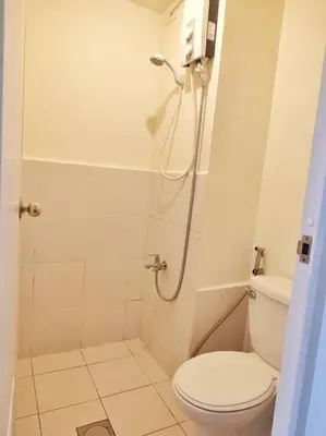 a white bathroom with a shower and a toilet at Urban Deca EDSA Staycation w/Unli Wi-Fi & Netflix in Manila