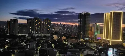 a city skyline at night with tall buildings at COAST RESIDENCES in Manila