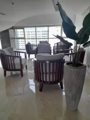 a lobby with chairs and a potted plant in a building at COAST RESIDENCES in Manila