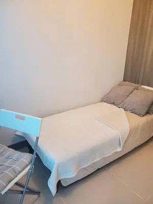 a small bed in a room with a table at COAST RESIDENCES in Manila