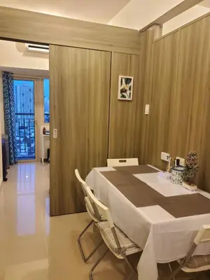 a dining room with a white table and chairs at COAST RESIDENCES in Manila