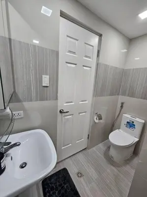a bathroom with a white toilet and a sink at BGC Beautiful Large 1 Bedroom Condo Sleeps 3 Adults in Manila
