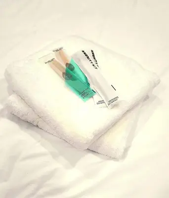 a white towel with two toothbrushes on a bed at BGC Beautiful Large 1 Bedroom Condo Sleeps 3 Adults in Manila