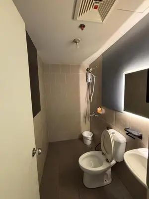 a bathroom with a toilet and a sink at Holland Park Condominium in Jalang