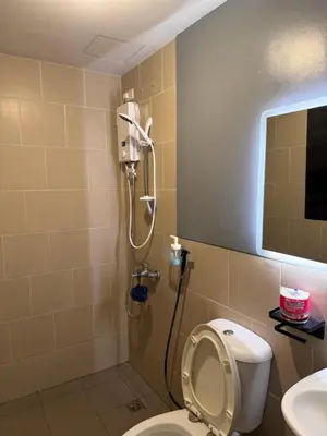 a shower in a bathroom with a toilet and a sink at Holland Park Condominium in Jalang