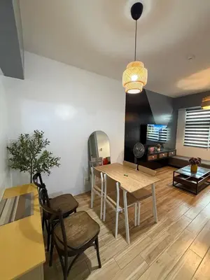a living room with a wooden table and a dining room at Holland Park Condominium in Jalang