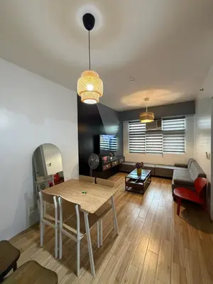 a living room with a table and a couch at Holland Park Condominium in Jalang