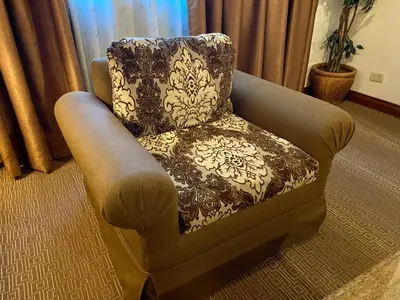 a chair sitting in a living room next to a window at Maharaja Oriental Suite Makati in Manila