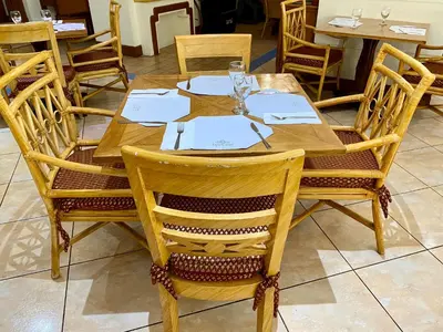a wooden table with plates and glasses on it at Maharaja Oriental Suite Makati in Manila