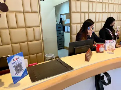 two women sitting at a counter talking on a cell phone at Maharaja Oriental Suite Makati in Manila
