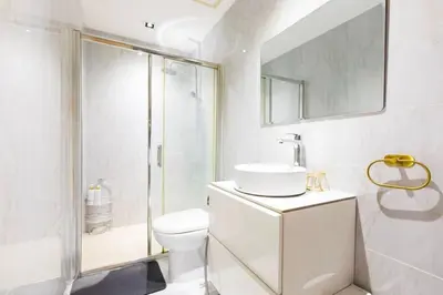 a bathroom with a toilet and a shower and a sink at Kaiyana Apartments in Manila