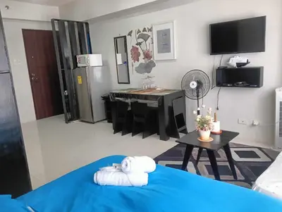 a room with a bed and a table with a room at Ilustrata Residences Condominium in Manila