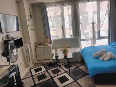 a living room with a bed and a tv at Ilustrata Residences Condominium in Manila