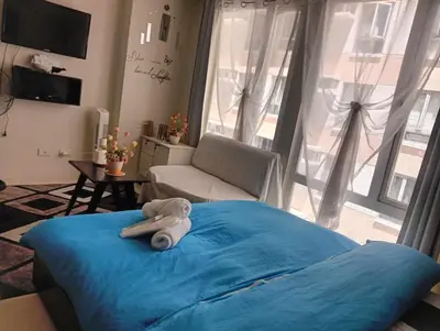 a bedroom with a blue bed with a towel on it at Ilustrata Residences Condominium in Manila