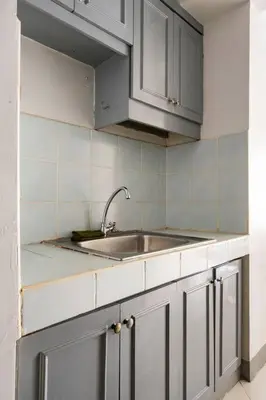 a kitchen with white cabinets and a sink at Pacific Regency, Manila studio type with balcony in Manila