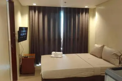 a bedroom with a large bed and a window at Spacious Studio Apartment B306 in Manila