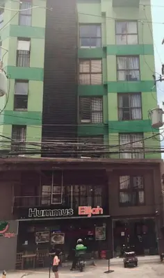 a tall green building with a sign on it at Spacious Studio Apartment B306 in Manila