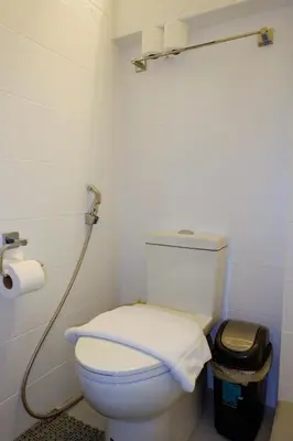 a bathroom with a white toilet with a hose at Z Hostel in Manila
