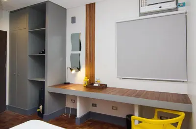 a desk in a bedroom with a yellow chair at Z Hostel in Manila