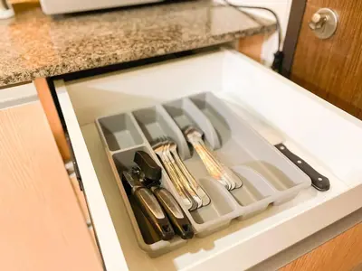 a kitchen sink with utensils in a drawer at BGC's Best Condo Near Uptown Mall #oursw15o in Manila